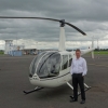 Instructor standing by R44 helicopter