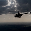 R44 silhouette against grey clouds